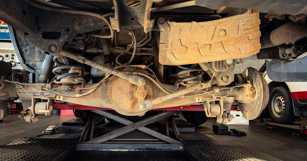 Rear axle and differential housing of a vehicle on a lift, where a billet differential cover is fitted